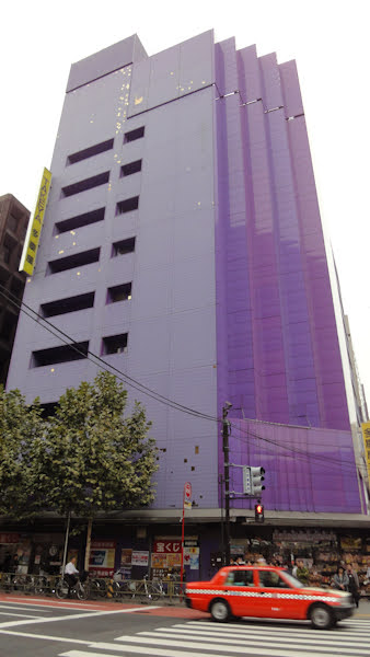 a tall purple building with very few windows